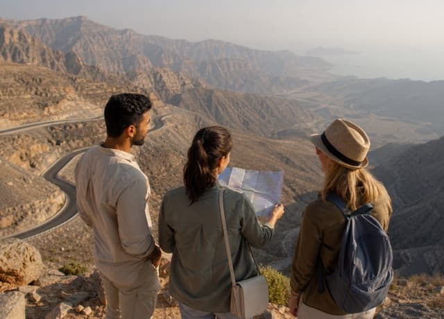 International travelers overlooking the winding Jebel Jais mountain road